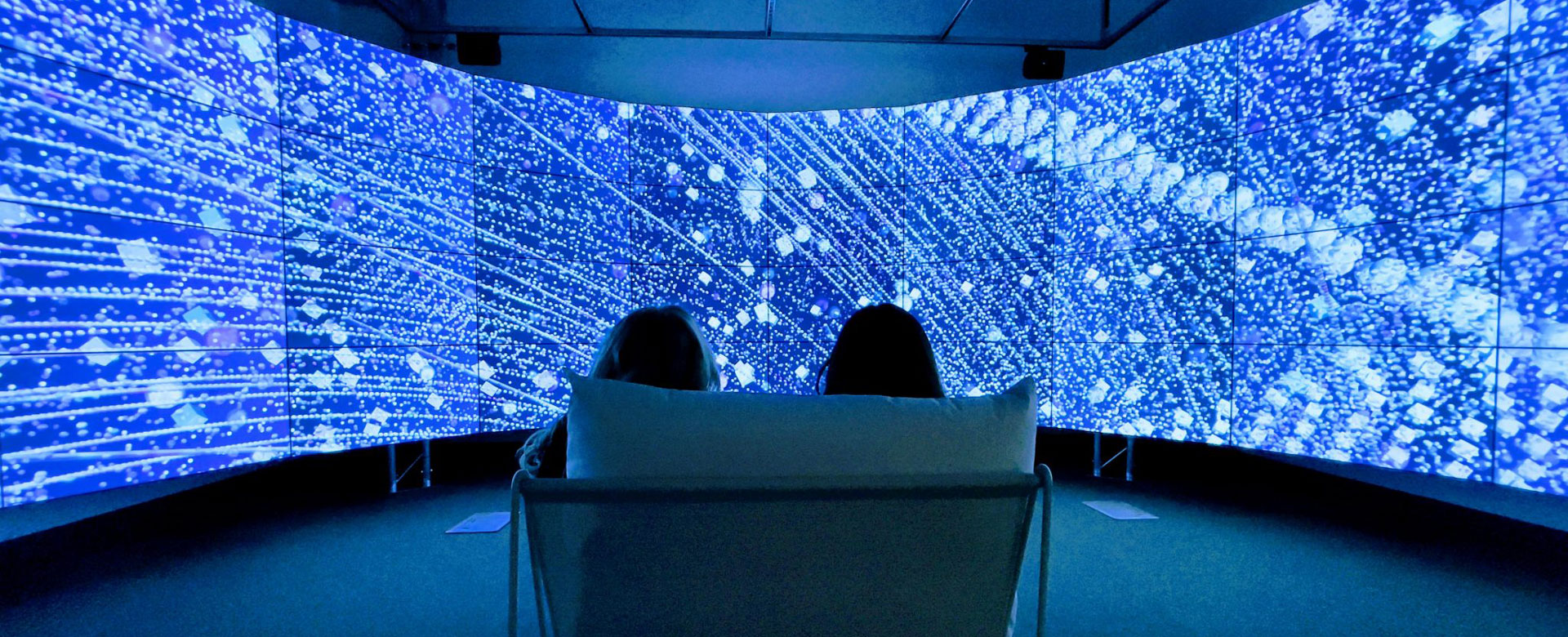 Students sitting in front of the All the Stars We Cannot See exhibit
